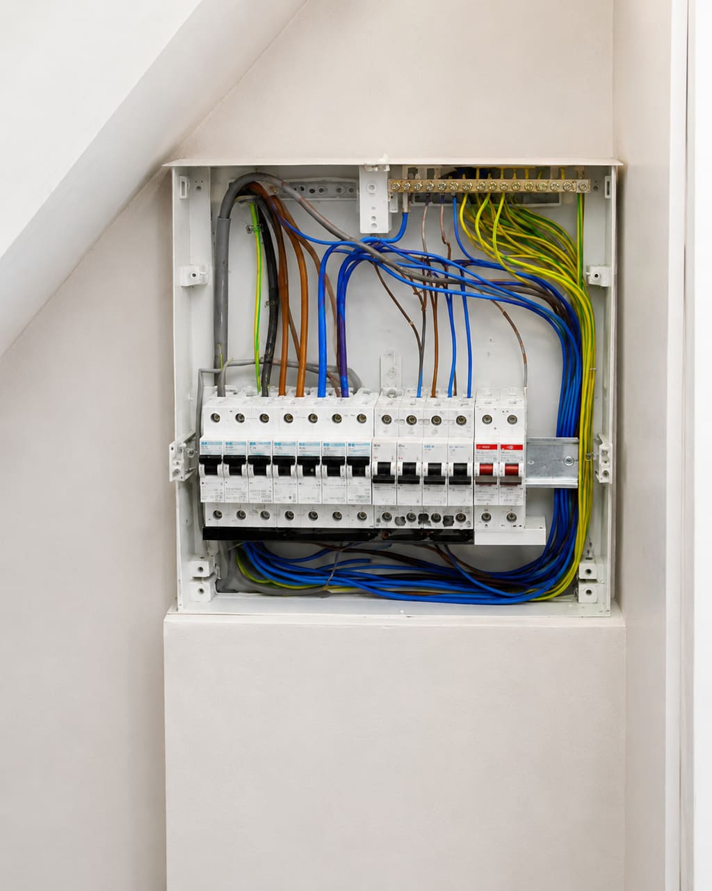 The same consumer unit, photographed properly: shot square on in daylight from the open doorway, floor cleared, labels legible.