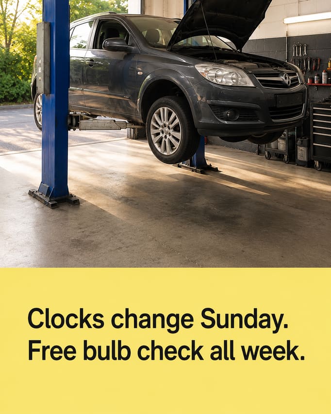 The same car in a new scene, shot low from three-quarters on with the shutter open behind it and late daylight coming in, and the words “Clocks change Sunday. Free bulb check all week” on a pale yellow panel.
